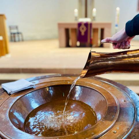 Wasser in Taufstein gegossen